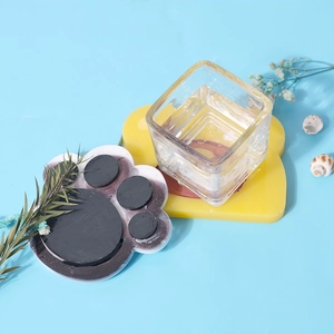 Dettaglio di sottobicchieri in silicone a forma di zampa di gatto e orso giallo