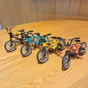 Miniature mountain bike keychains in four colors: black, sky blue, yellow, and orange