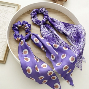 Detailed view of purple satin scrunchies with polka dots and abstract floral patterns