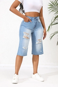 Close-up of high-waisted light blue distressed denim shorts with ripped details
