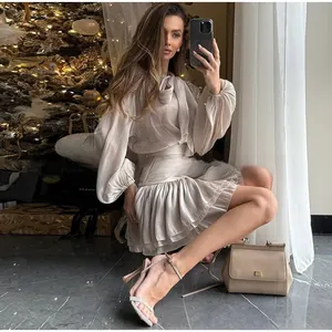 Detail von champagnerfarbener Satinbluse mit Schleife und gerafftem Minirock mit hoher Taille