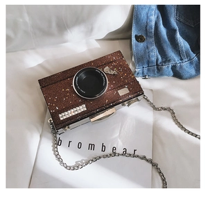 Detail of sequined camera-shaped evening bag with star patterns and silver metal chain