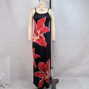 Close-up of vibrant red lily floral print on a sleek black bodycon summer maxi dress