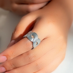Macro shot of silver stainless steel ring with wave texture design on model hand