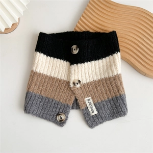 Macro detail of striped knit neck warmer with decorative buttons and leather label