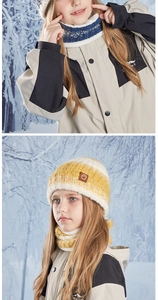 Close-up of children's thick knitted hat and neck warmer with leather logo detail