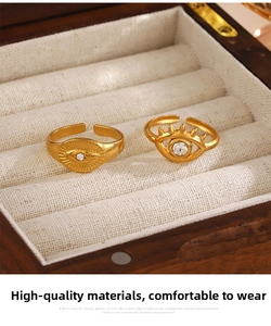 Detail of gold evil eye rings with rhinestone inlay in a wooden jewelry gift box