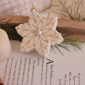 Chic cream snowflake Christmas ornament with gold and silver details on rustic book