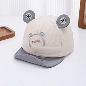 Detalle de gorra de sol para bebé con diseño de oso bordado y textura de tela suave