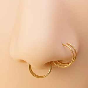 Detailed view of gold stainless steel double hoop nose rings on a silicone nose model