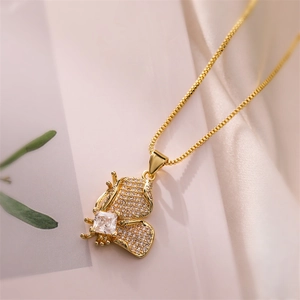 Close-up of gold butterfly pendant with sparkling cubic zirconia and square center stone