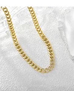 Detailed close-up of gold plated Cuban chain with zircon pavé links on white stone