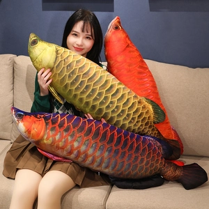 Realistic large golden dragon fish plush pillow held by a model for size comparison