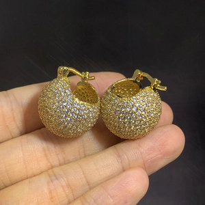 Macro detail of gold-plated ball hoop earrings with micro-pave zircons and spring closure