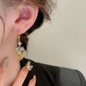 Detail of heart fringe tassel earrings with gold plating and sparkling zircon stones