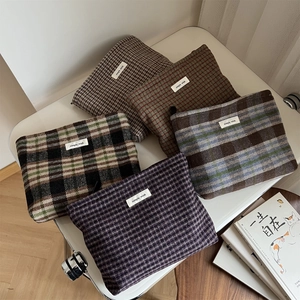 Detailed view of five vintage plaid wool makeup bags with zippers and woven labels