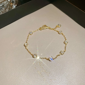 Detail of gold chain bracelet with round zircon stones and lobster clasp closure