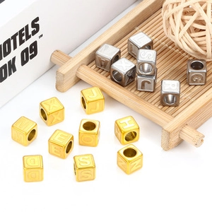 Macro detail of cube-shaped alphabet beads in gold and silver for DIY jewelry crafts