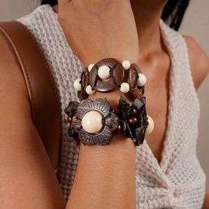 Detailed close-up of stacked ethnic wooden bead bracelets with coconut shell textures