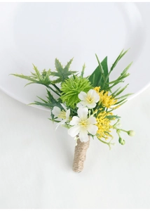 Close-up of white artificial boutonniere with green leaves and jute twine handle