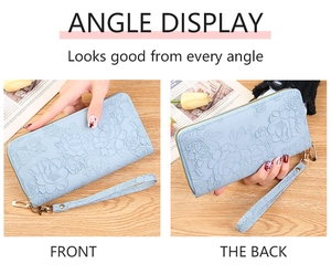 Close-up of light blue long wallet with floral embossing and gold zipper detail