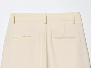 Détail du pantalon beige en tissu tissé texturé avec poches arrière et passants de ceinture