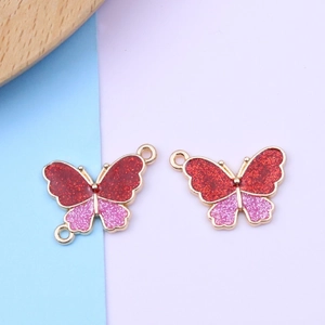 Macro view of butterfly charms with red and pink glitter in alloy metal frames