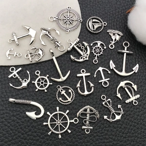 Detailed view of silver nautical charms including anchor, rudder, and sailboat shapes