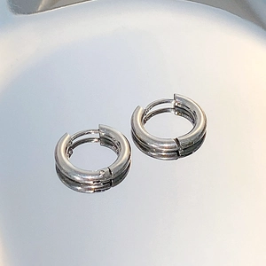 Macro shot of minimalist silver hoop earrings with a mirror-like metallic finish