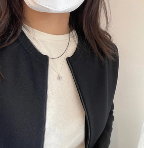 Detail of layered sterling silver necklaces featuring a minimalist smiley face pendant