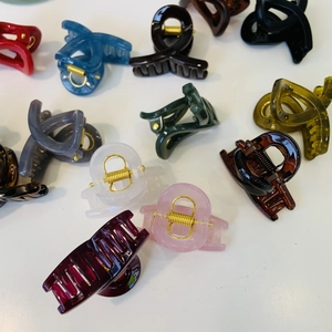 Close-up of assorted glossy resin hair claws with durable golden metal springs