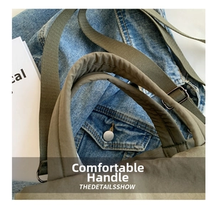 Detail of padded nylon handle and adjustable shoulder strap on khaki tote bag