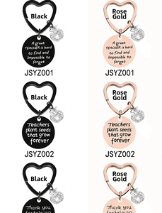 Detail view of heart keychains with crystal apple charms in black and rose gold finishes