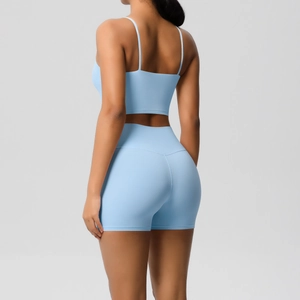 Detail of light blue sports bra back and high-waisted shorts on a fitness model