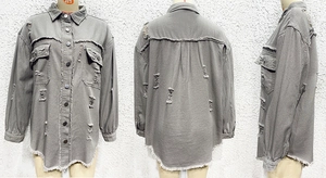 Detail view of grey denim jacket with distressed ripped holes and raw hem design