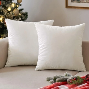 Set of two soft white velvet decorative throw pillow covers in a cozy holiday scene