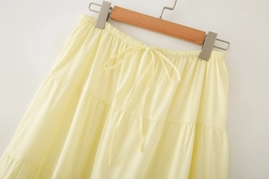 Detail of light yellow tiered skirt showing elastic waist design and bow drawstring tie