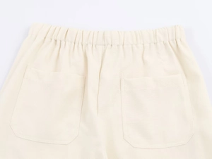 Dettaglio dell'elastico in vita e delle doppie tasche posteriori sui pantaloni larghi