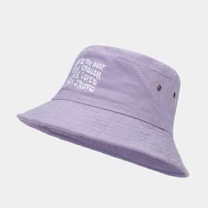 Detail view of purple cotton bucket hat featuring white letter embroidery and metal eyelets