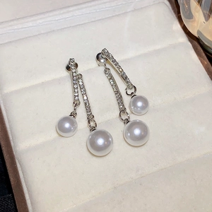 Macro view of silver fringe earrings with shimmering cubic zirconia and white pearls