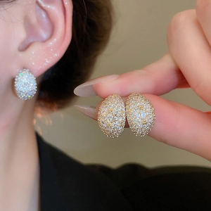 Macro shot of gold-plated oval stud earrings with pavé set cubic zirconia crystals