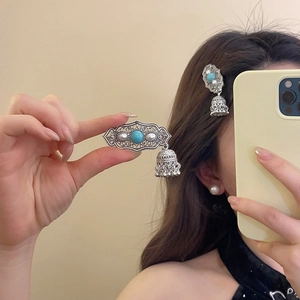Close-up of silver tassel hair clip with turquoise stones and white pearls on hair