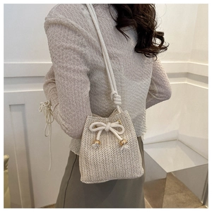Detail of hand-woven bucket bag with cream cotton rope and gold-tipped drawstring