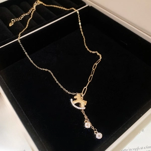 Detail of gold-plated rocking horse necklace with micro-pave crystals in a velvet box