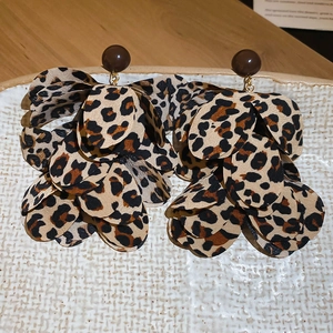 Detail of leopard print chiffon flower earrings with brown bead stud on ceramic tray