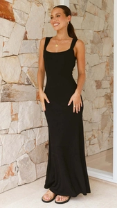 Détail d'une robe mi-longue noire moulante dos nu avec fente latérale pour femme en extérieur