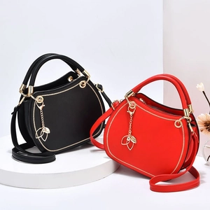Luxury red and black round handbags with gold leaf charm and adjustable shoulder straps