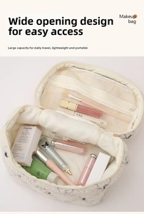 Detail view of large white plush makeup bag with floral patterns and interior mesh pocket