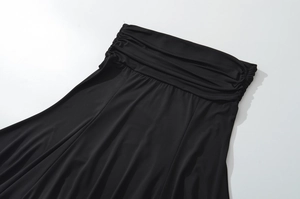 Detailopname van de zwarte onregelmatige plooistof en gerimpelde taille van de rok