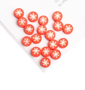 Macro shot of red polymer clay beads with white snowflake patterns for DIY jewelry craft